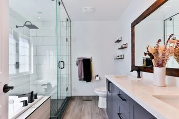 Modernes Badezimmer mit großer Glasdusche, Doppelwaschbecken und Dekoration