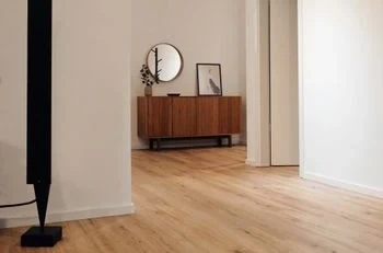 Helles Wohnzimmer mit modernem Holzfußboden und minimalistischer Kommode im skandinavischen Stil.