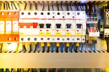 Sicherungskasten mit mehreren Sicherungen und farbigen Kabeln für Elektroinstallation.